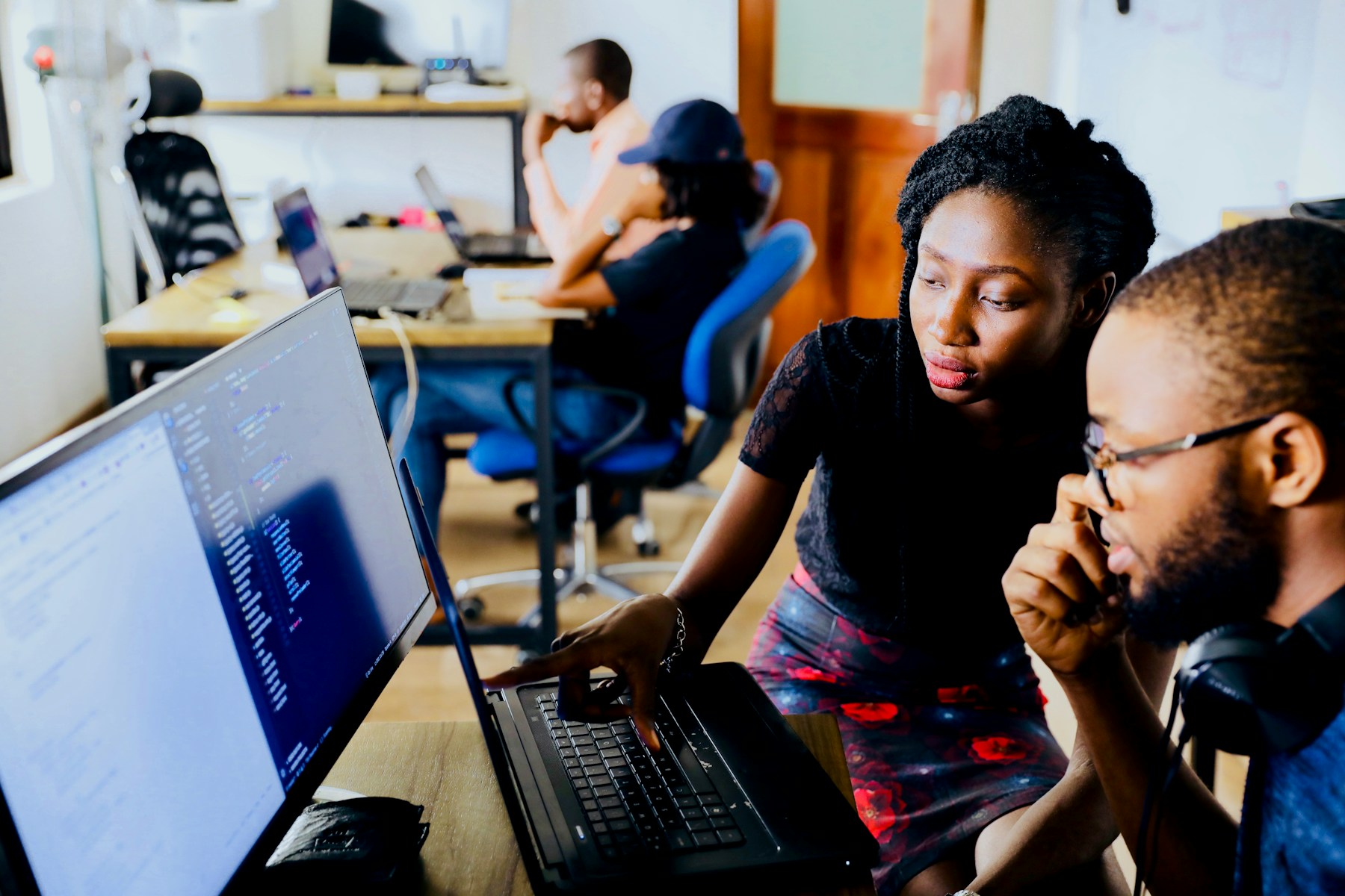 Colleagues collaborating at computers in Lagos, Nigeria